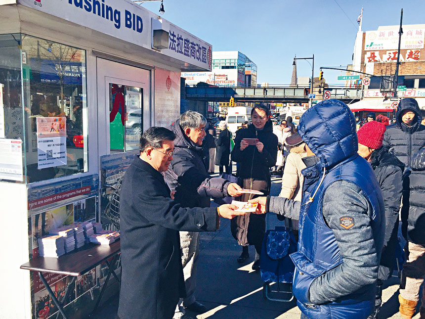 市議員顧雅明與法拉盛商改區共同主席莊振輝一同向民眾發放折扣券。