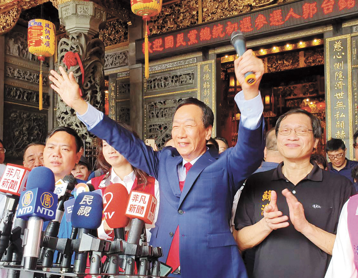 圖為國民黨總統初選參選人郭台銘(中)到屏東造勢,受到支持者熱烈歡迎。中央社