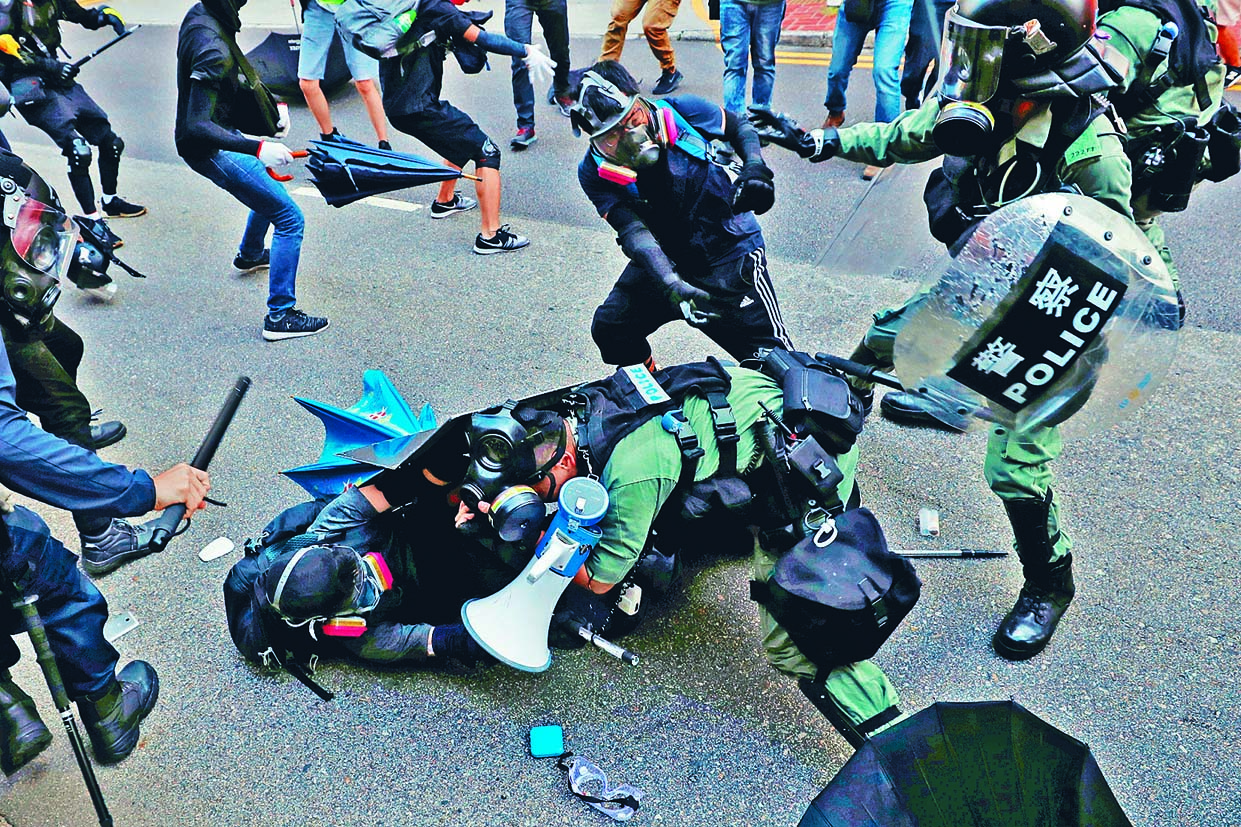 一名示威者圖趁防暴警拉人時,圖從後
搶槍,幸及時遭制止。 路透社