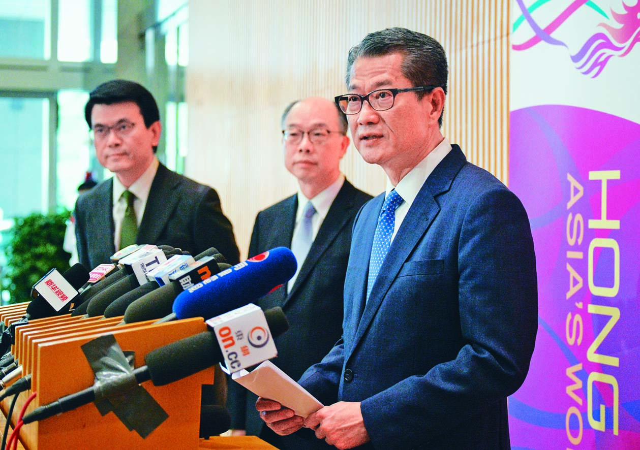 財政司司長陳茂波(右)、商經局局長邱騰華(左)和運房局局長陳帆,公布新一輪涉及二十億元開支的「撐企業、保就業」措施。