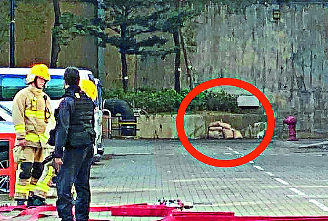 警方在危險品附近堆起沙包(圓圈示),準備引爆。