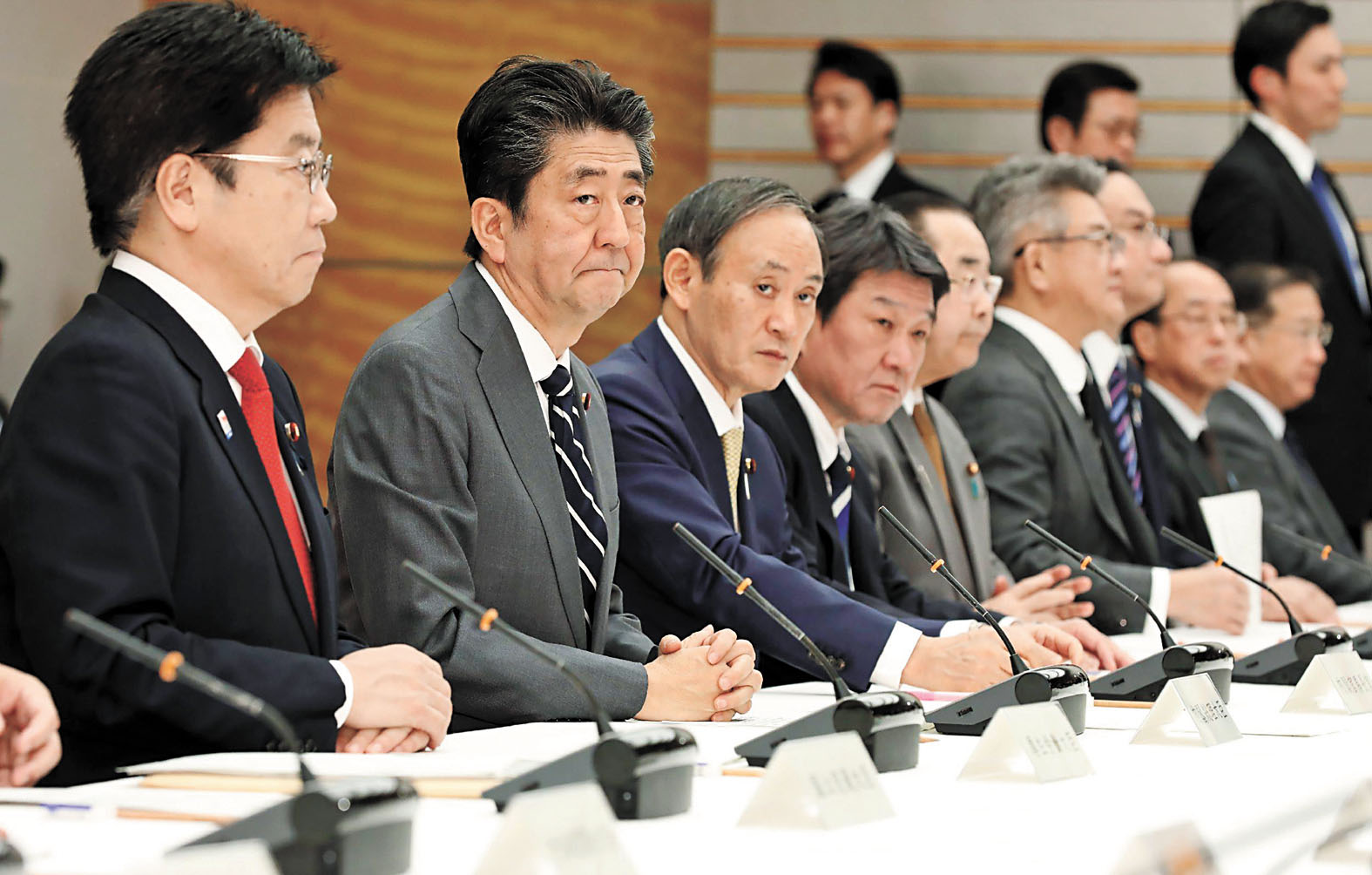 日本首相安倍晉三(左二)和厚生勞動大臣加藤勝信(左一)出席有關新冠肺炎的會議。 美聯社