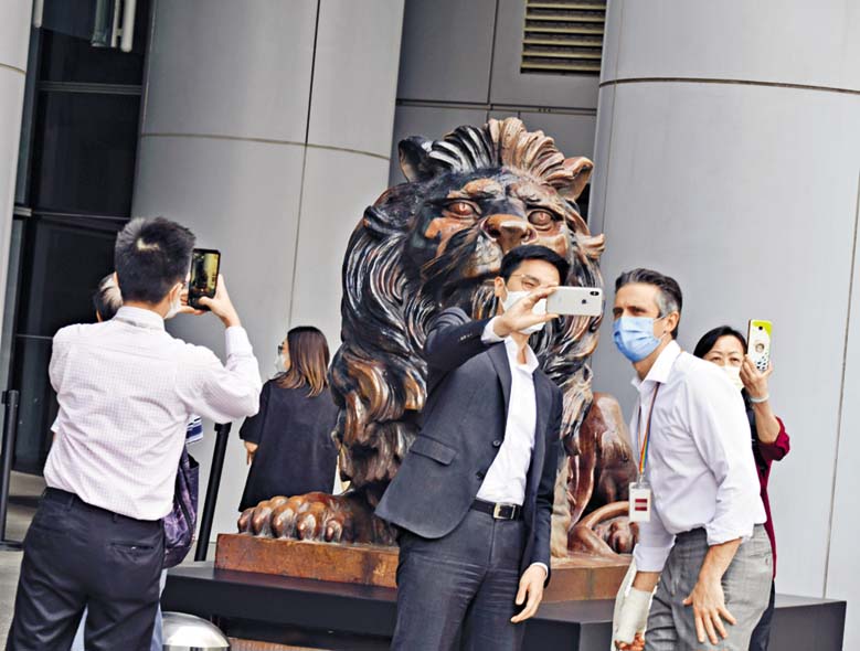 市民用不同拍照方
式,爭取攝下銅獅復修
後的容貌。 褚樂琪攝