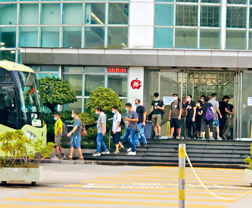 21日大樓門外的公司車,看見仍有不少員工如常上下班。徐裕民攝